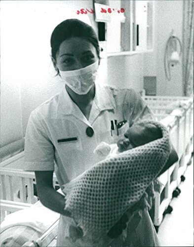 Foto vintage de uma enfermeira carregando o bebê da princesa Maria Gabriella.